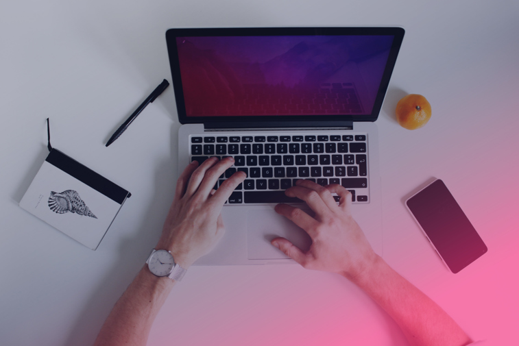 Laptop med händer som skriver på tangentbord.