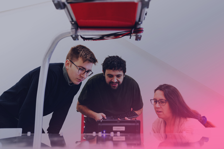 Bild tagen i profil. Ung man sitter vid ett mikroskop och tittar på någonting.