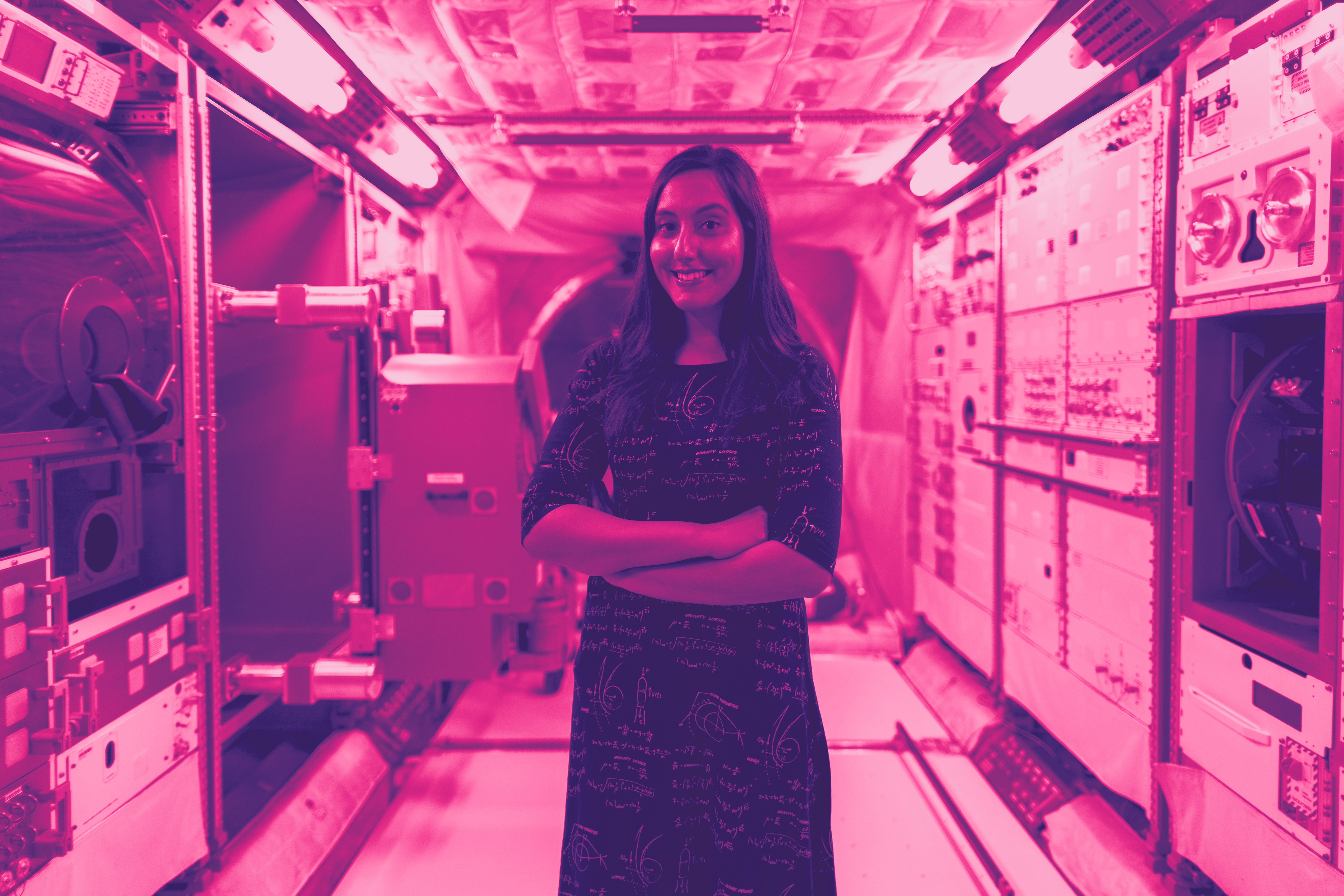Woman standing in spaceship with arms crossed.