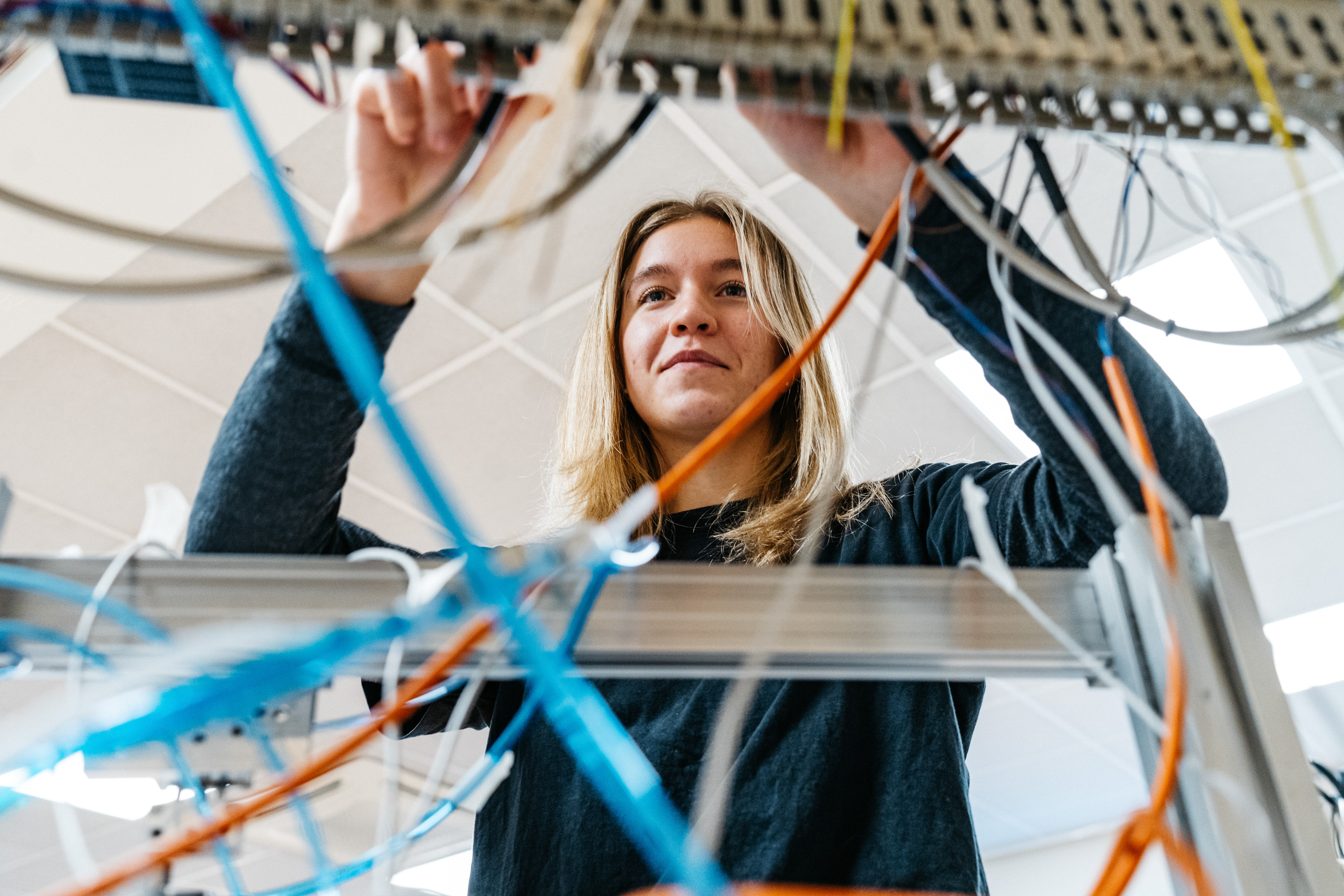 Young woman with long nails soldering together a circuit board.