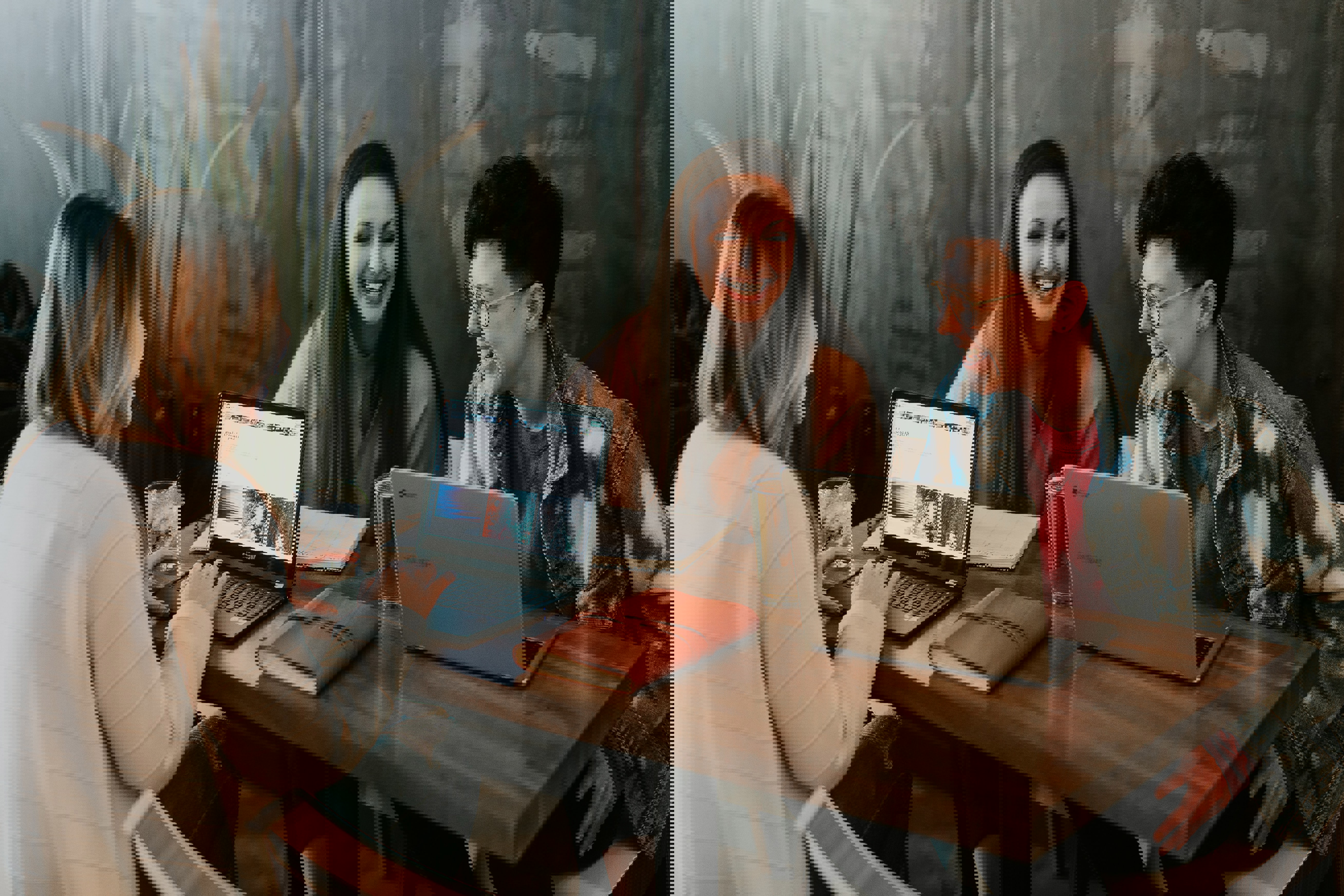 Tre personer skrattar medan de arbetar med sina datorer.